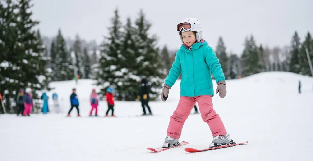 Jeune enfant concentré apprenant les premiers virages sur une piste verte sécurisée