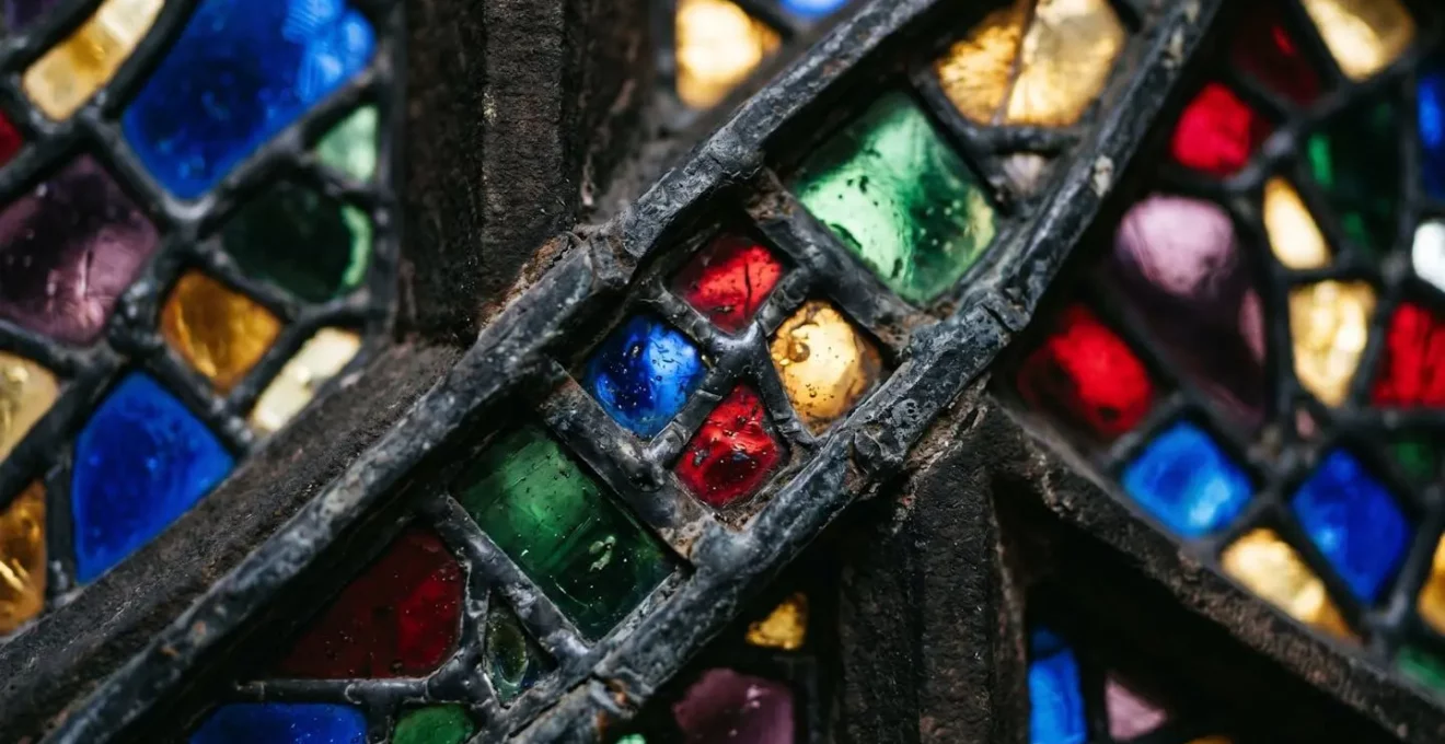 Détail macro d'une rosace gothique avec vitraux colorés et jeux de lumière naturelle