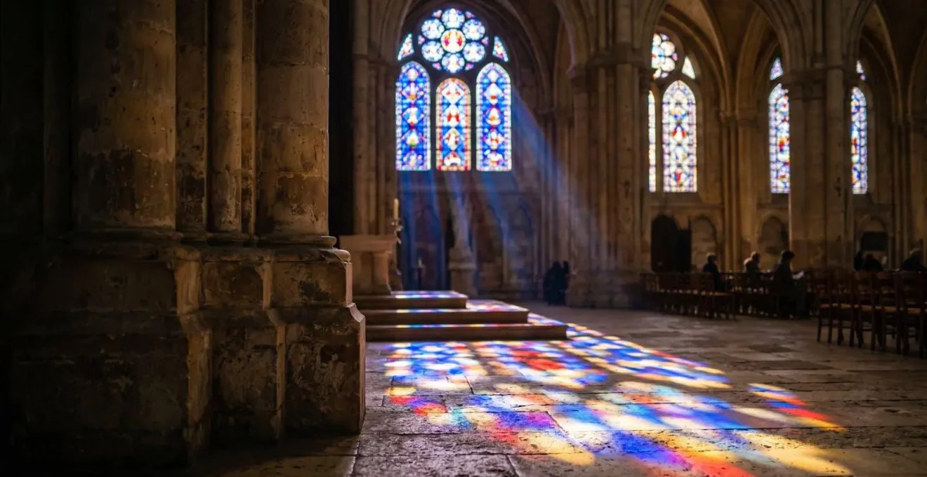 Lumière dorée traversant les vitraux bleus emblématiques de la cathédrale de Chartres