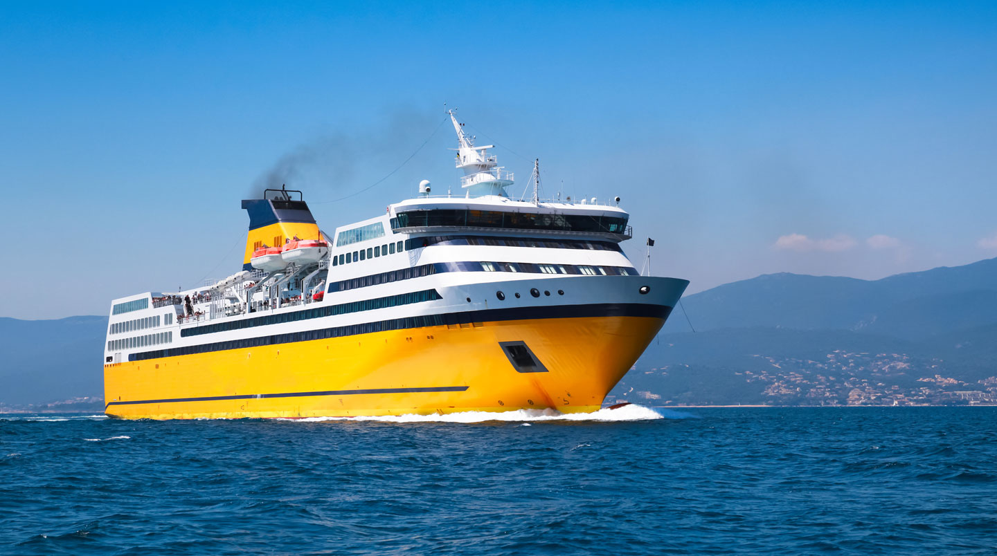 Un ferry moderne amarré dans un port méditerranéen sous un ciel dégagé avec infrastructure portuaire contemporaine visible